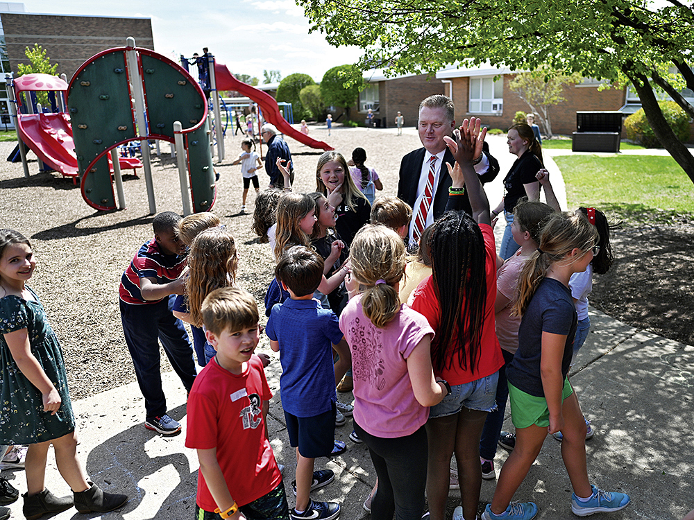 Davidson surrounded by students on campus.