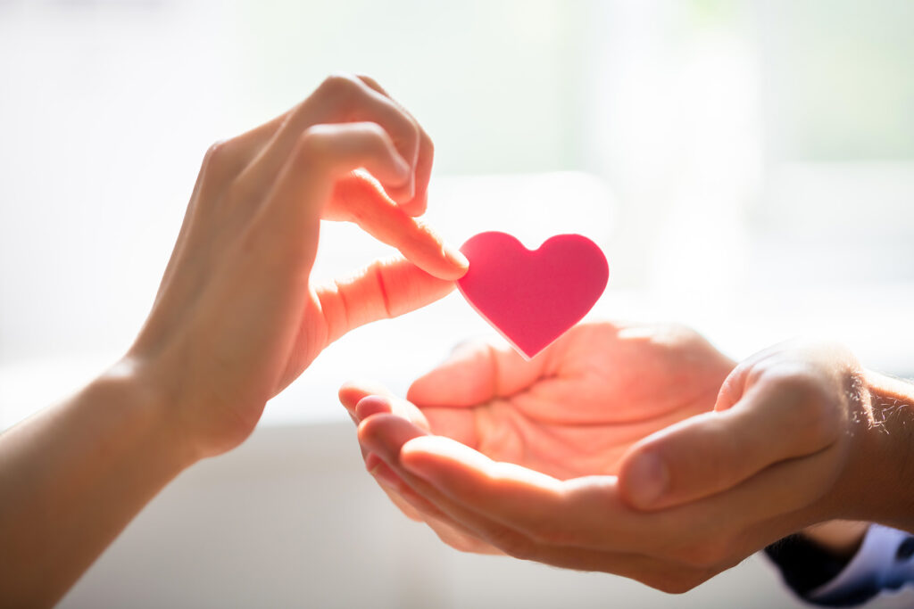 Woman Giving Heart On Man's Hand