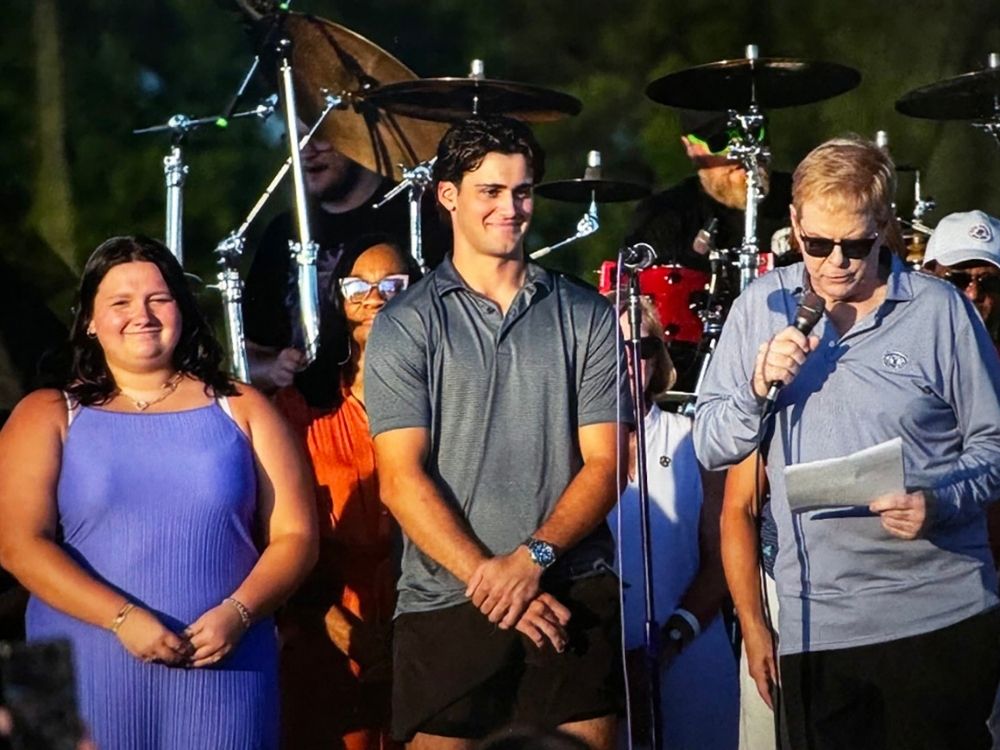 The 2024-25 winners were honored at Taste of Oak Brook last July.  Vija Barber (l) and James Philipneri (c) on stage with committee chairman Tom Truedson (r). 