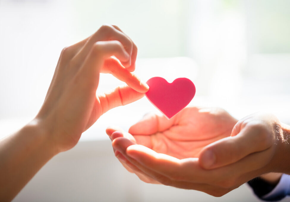 Woman Giving Heart On Man's Hand