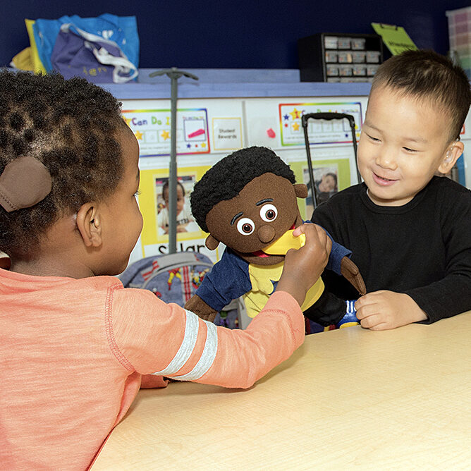 Interactive play between preschool students encourages language exposure.