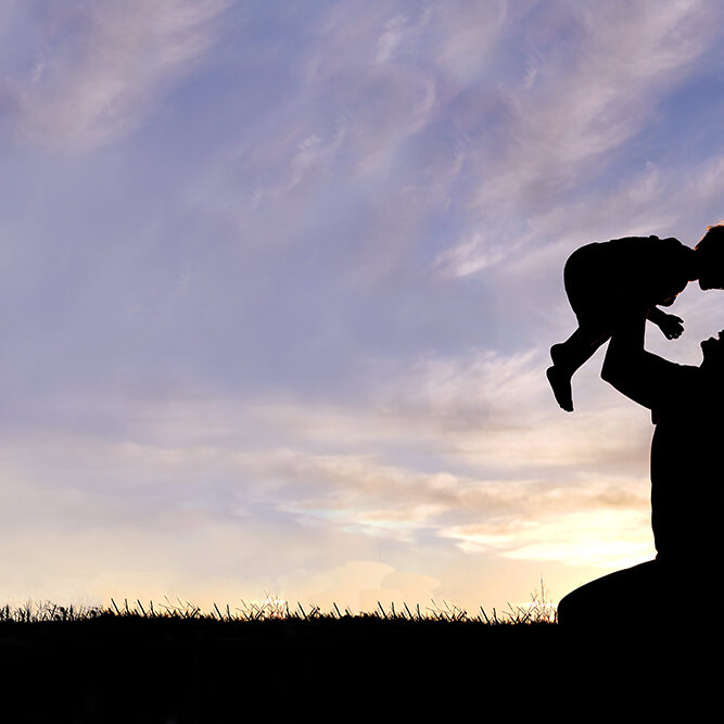 Silhouette of Happy Mother Playing Outside with Baby