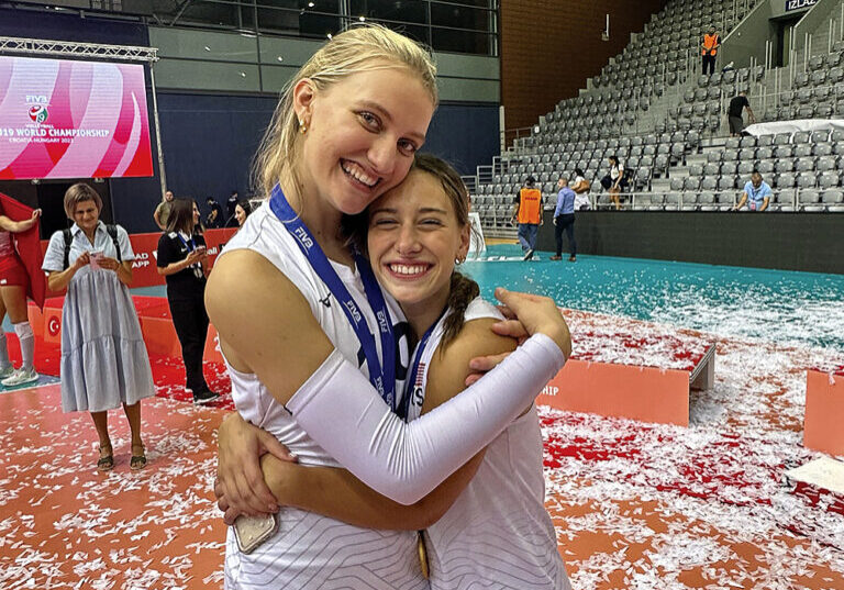 Timothy Christian’s Abby Vander Wal and Immaculate Conception’s Ava Falduto hug after winning a world championship in volleyball.