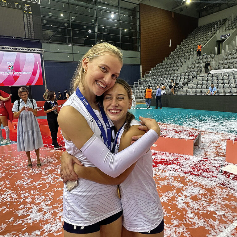 Timothy Christian’s Abby Vander Wal and Immaculate Conception’s Ava Falduto hug after winning a world championship in volleyball.