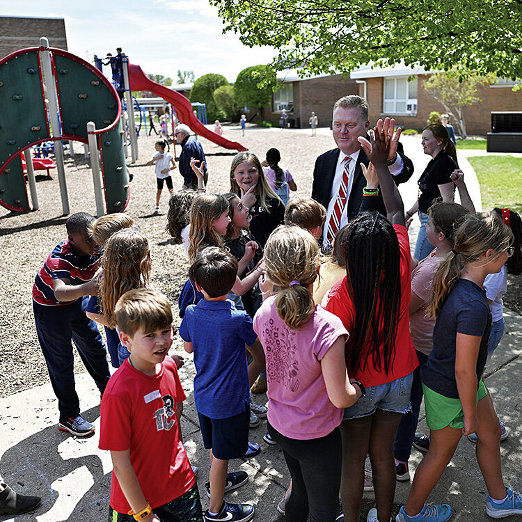 Davidson surrounded by students on campus.